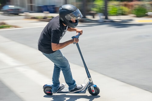 Man leaning hard into turn on Unagi Model One electric scooter