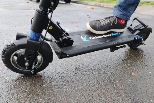 Close up of electric scooter deck with foot placed on it