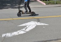 Close up of man riding an electric scooter