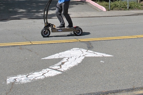 Close up of man riding an electric scooter