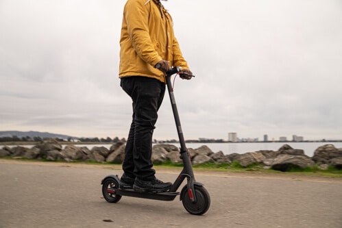 Xiaomi M365 Pro electric scooter - man riding to right of frame, cropped