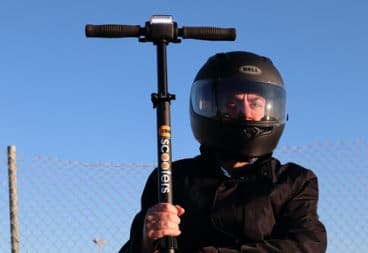 Man wearing helmet and holding electric scooter