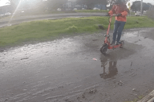 Man riding the QPower electric scooter through mud in slow motion