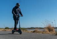 Man cruising on the Apollo Pro electric scooter
