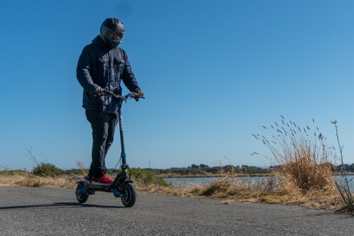 Man cruising on the Apollo Pro electric scooter