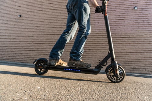 Man Riding Hiboy Max V2 Electric Scooter with deck lights on (waist down)