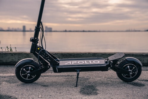 Apollo Ghost electric scooter - front wheel, deck, kickstand rear wheel, footrest, side view, cropped view