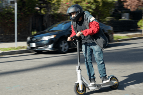Segway Ninebot Max Electric Scooter - Man riding scooter, full view, riding downhill