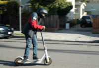 Segway Ninebot Max G30LP Electric Scooter - Man riding on scooter, full view, in motion, side view