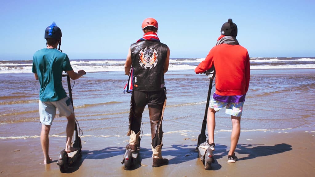 Christian, Graham, and Brandon touch the Pacific Ocean with their scooters (end of trip) | Credit: Scooter Crossing