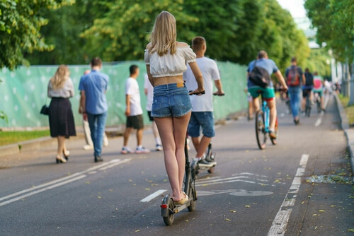 people riding scooters among bikers and pedestrians