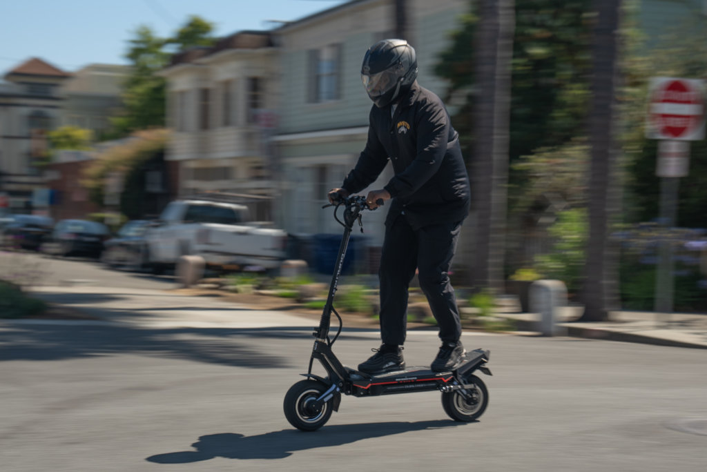 Minimotors Dualtron Storm electric scooter - man riding fast, thru intersection