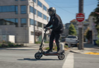 Minimotors Dualtron Storm electric scooter - man riding thru intersection